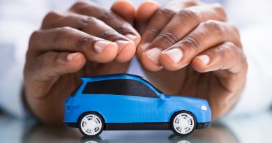 A imagem mostra uma pessoa com as duas mãos protegendo um carro azul fazendo alusão ao seguro veicular e rastreador veicular